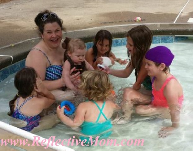 Little girls admiring baby at the pool